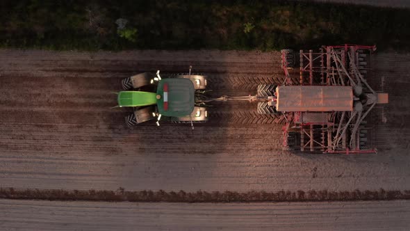 AERIAL - Tractor sowing seeds at dusk, Dalarna, Sweden, tracking left plan view