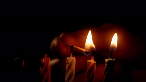 Closeup View of Person Burning Birthday Candles with Match