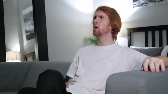 Excited Redhead Man Reacting to Success Watching TV