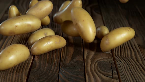 Super Slow Motion Shot of Potatoes Rolling on Old Wooden Table at 1000Fps