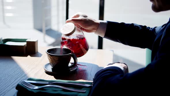 Closeup Shot of Cafe Visitor Pouring Tea From Teapot to Beautiful Original Clay Teacup