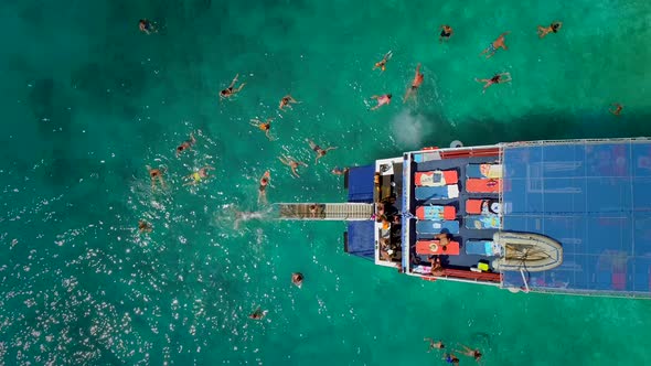 Aerial view of people in ferry diving on the sea, Ithaki island, Greece.