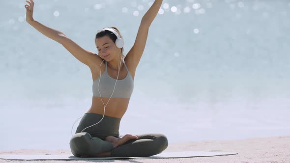 Sporty Woman with Headphones on the Beach