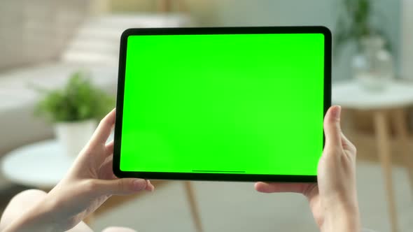 Point of View of Woman Holding and Using Hand Gestures on Green Mock-up Screen Digital Tablet