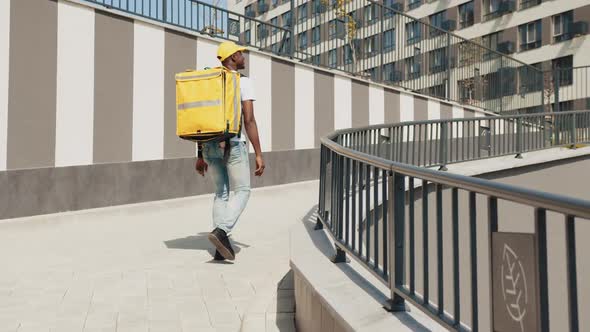 Handsome African American Courier Delivery Worker Cap and Medical Mask Walking