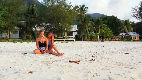 Girls enjoying life on beautiful coastline beach trip by blue water and white sandy background of Th