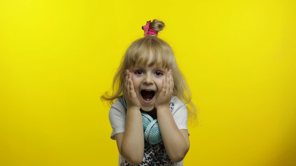 Child Show Amazement, Fooling Around, Smiling, Looking Surprised Shocked on Yellow Background