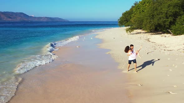 Young couple tan on paradise resort beach journey by blue green lagoon with white sandy background o