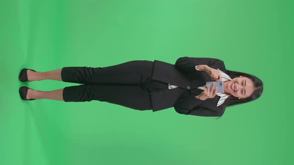 Full Body Of Asian Business Woman Enjoy Using Mobile Phone While Standing On Green Screen