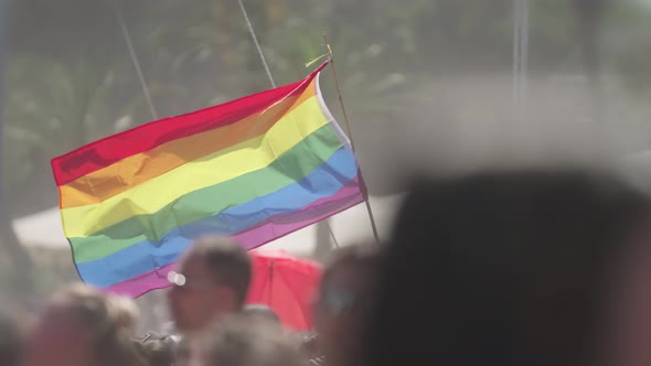 LGBTQ rainbow flag waving in slow motion during the main party in a pride parade