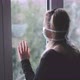 Woman at Window with a Mask in Isolation for Virus Outbreak - VideoHive Item for Sale