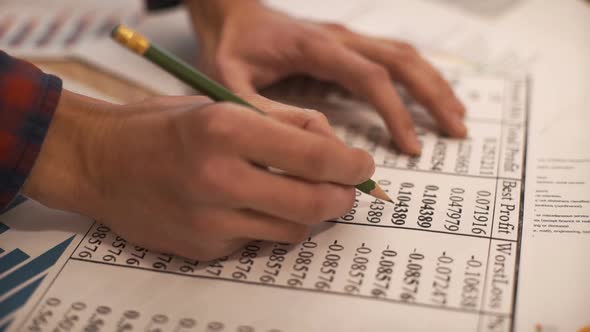 The Businessman Examines Documents with Diagrams and Graphs