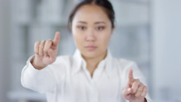 Asian Woman Using Invisible Futuristic AR Touchscreen in Office