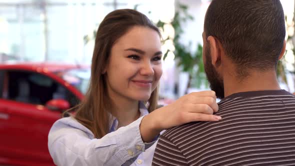 Girl Hugs Her Boyfriend at the Dealership