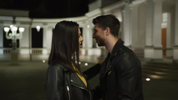 Young couple hugging in a park at night