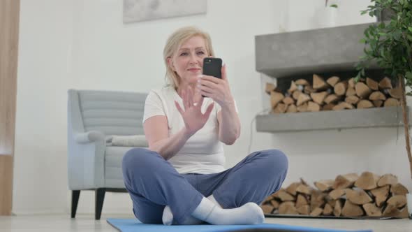 Senior Old Woman Using Smartphone on Yoga Mat at Home
