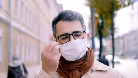 A Handsome Man of Oriental Appearance Takes Off His Medical Mask