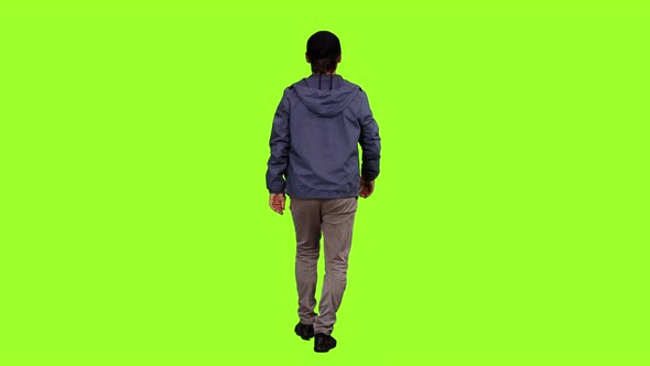 Rear View of a Male in Casual Wear Walks on Green Background