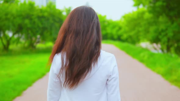 Trendy Casual Girl in White Hoodie Walks in City