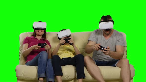 Family Playing in the Game of Virtual Masks Sitting on the Sofa. Green Screen