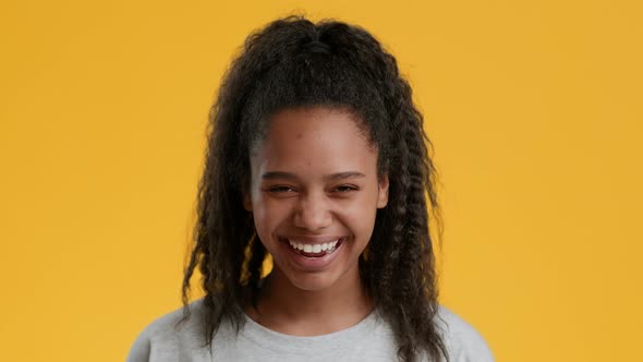 African American Teen Girl Laughing Out Loud Over Yellow Background