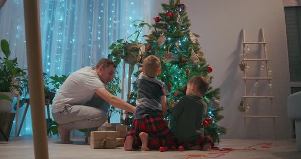 A Family with Two Children Decorate a Christmas Tree on Christmas Eve