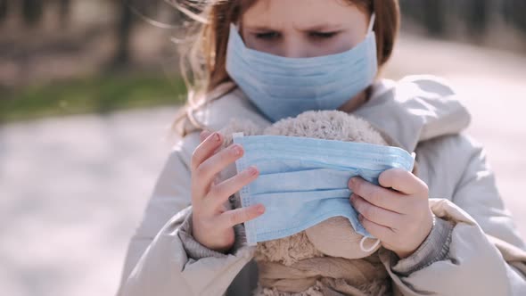 The Girl in a Mask Is Putting a Mask on Teddy Bear Toy