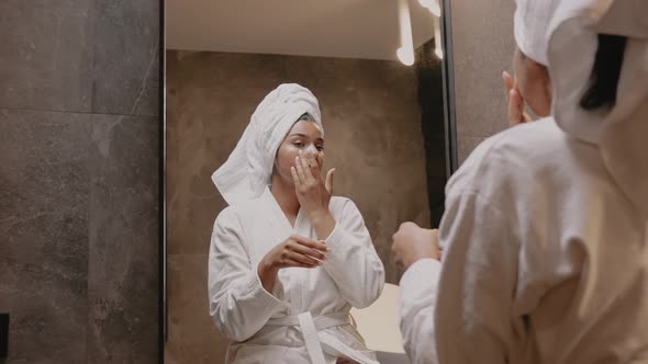 Young Darkskinned Brunette in Front of a Mirror in a Dressing Gown