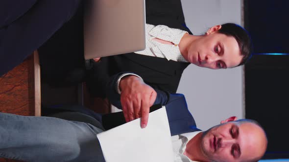 Businessman Doing Overtime Helping Coworker Using Laptop