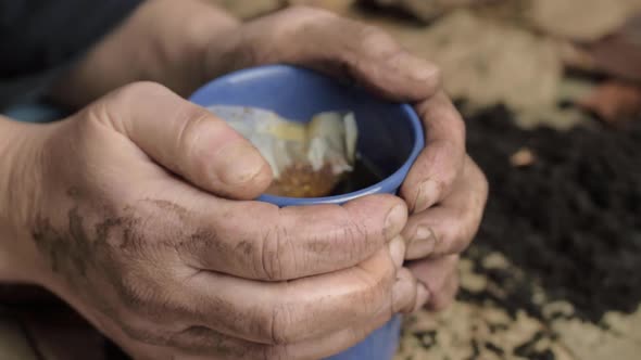 Dirty pair of cold hands warming on a hot drink