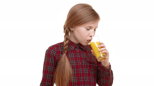 Cute Smiling Elementaryschool Aged Girl with Plait of Hair Drinking Tasty Orange Juice with Great