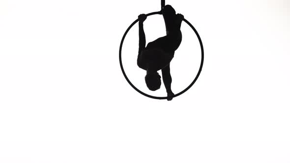 The Black Silhouette of an Aerial Gymnast Performing Acrobatic Tricks and Spinning in the Air on the