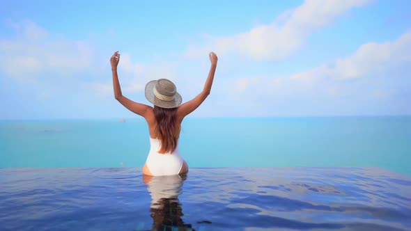 Young asian woman enjoy around outdoor swimming pool for leisure