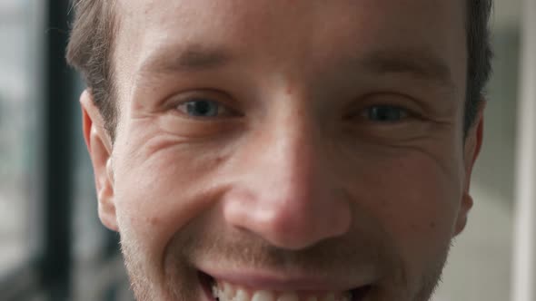 Close up portrait of handsome businessman smiling cheerfully to the camera. In formal wear standing