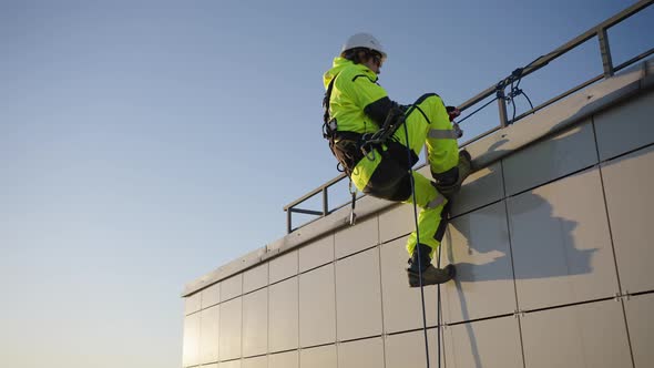 Industrial Climber Goes Down Wall of Glass Skyscraper