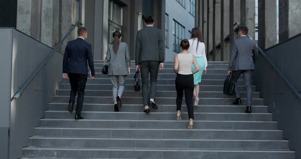 Six Business People Walking up the Stairs