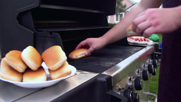 Man Preparing Hot Dogs on a Grill