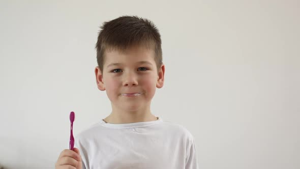 Kid Boy Brushing His Teeth Using Tooth Brush and Oral Paste Cleaning Teeth