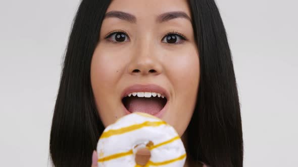 Cheerful Korean Lady Posing With Donut Over White Background