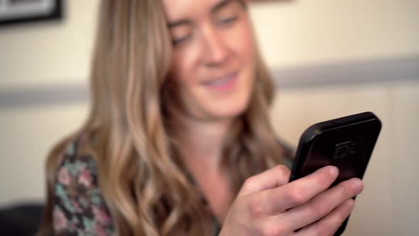 Attractive woman has surprised expression while using phone, pull focus close up low angle