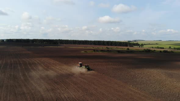 Orange Tractor Plows the Field