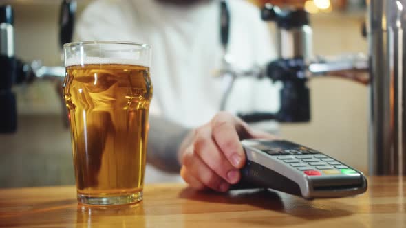 Buying Beer and Paying By Smartphone Closeup