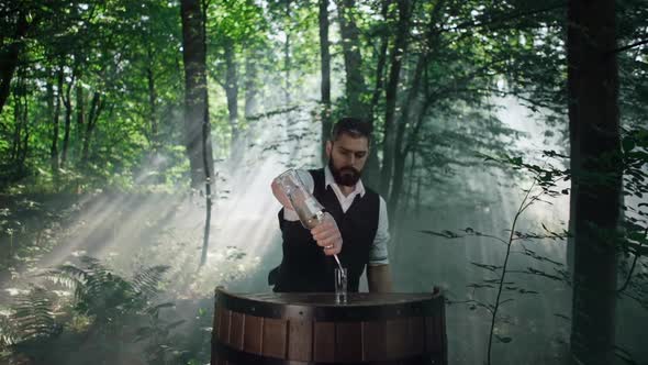 Bartender in Nature in the Forest Prepares a Drink  Shot