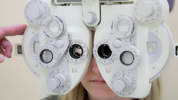 A male ophthalmologist checks a girl's eyesight using a phoropter. Vision treatment.