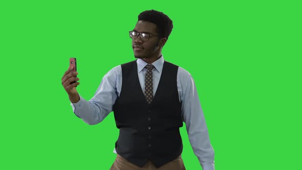 African American Businessman Making Selfies with His Phone While Walking on a Green Screen, Chroma