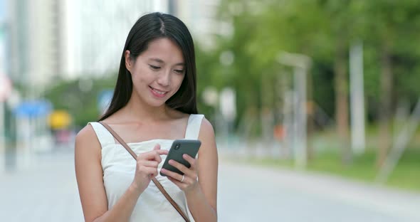 Asian woman use of mobile phone in city