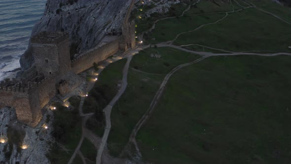 Aerial Evening Landscape Genoese Fortress on Mountain Top Black Sea Shore and Sudak City Sunset