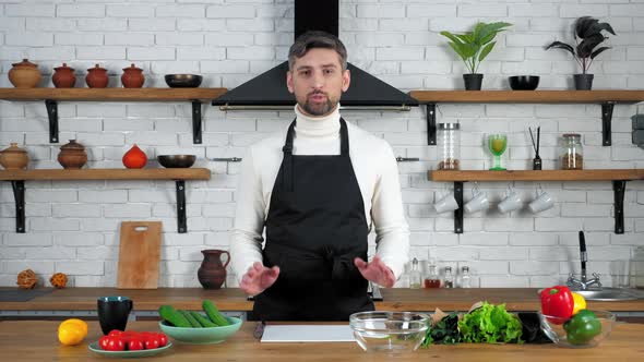 Man chef in apron listens teaches housewife shows ingredients for cooking salad