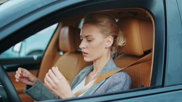 Closeup Woman Driver Buckling Seat Belt at Car. Woman Sitting at Front Seat