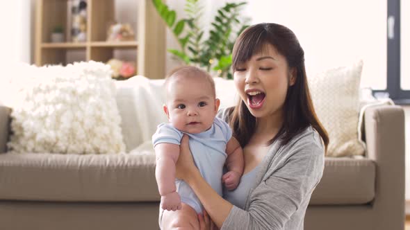 Happy Young Mother with Little Baby at Home